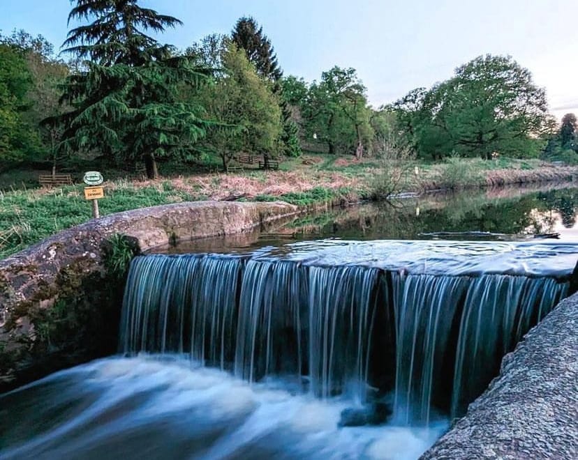 A image of a river can be seen with water cascading down a ridge.