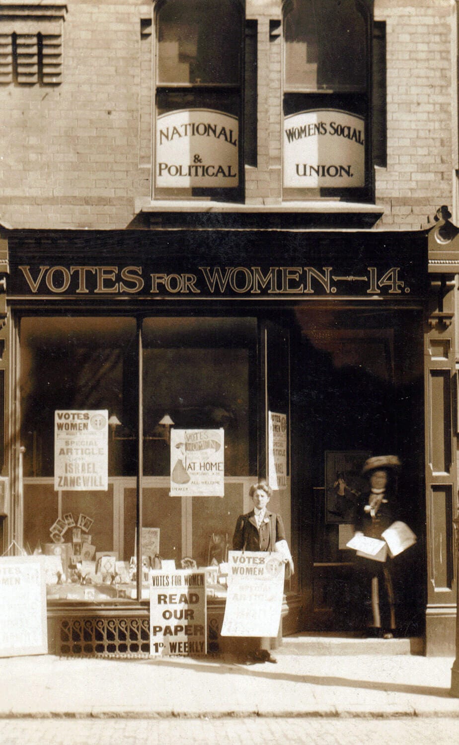 Two women stand outside the WSPU shop in Leicester.
